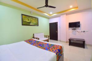 1 dormitorio con 1 cama y TV en la pared en FabHotel Knight Airways, en Guwahati