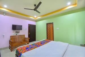 a bedroom with a bed and a flat screen tv at FabHotel Knight Airways in Guwahati