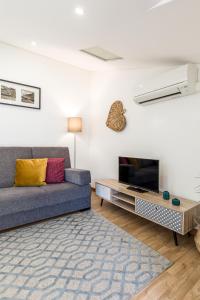 a living room with a couch and a tv at Apartment Bolhao Market by Sweet Porto in Porto