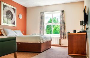 1 dormitorio con cama y ventana en Rob Roy Hotel en Aberfoyle