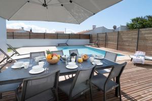 una mesa con un bol de fruta en el patio en Les mouettes/Piscine chauffée jusque déb. novembre en La Cotinière