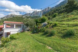 a house on a hill with mountains in the background at Apartment Josipa in Omiš +20 photos