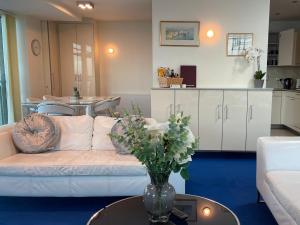 a living room with a couch and a table with flowers at Quay & Sea View Spacious Modern Secure Parking in Poole