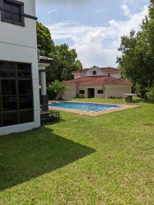 a backyard of a house with a swimming pool at Serene Holiday Chalet with pool in a quiet enclave in Kampong Alor Gajah