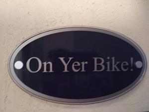 a sign that reads on yet bike on a wall at On Yer Bike & Gone Fishin in Millport