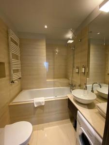 a bathroom with a tub and a sink and a toilet at Platinum Residence in Warsaw