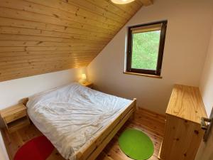 PłaskaにあるDomek apartament w Puszczy Augustowskiejの木製の部屋にベッド1台が備わるベッドルーム1室があります。