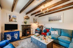 a living room with a blue couch and a tv at Smithy House in Lochgilphead