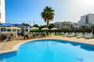 una piscina con sedie, tavoli e ombrelloni di Hotel Apartamentos Vibra Central City - Adults only a San Antonio