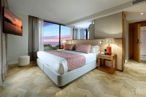 a bedroom with a large bed and a large window at TRS Ibiza Hotel - Adults Only in San Antonio