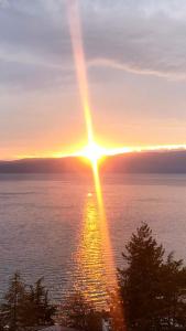 a sunset over the water with the sun in the sky at Villa Fania in Ohrid