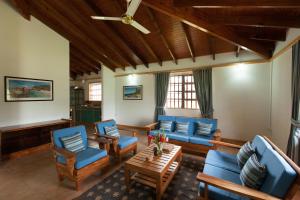 a living room with blue couches and chairs at Heliconia Grove in Baie Sainte Anne