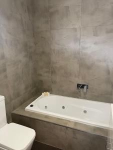 a bathroom with a white bath tub next to a toilet at Town & Country Motor Inn in Forbes