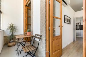 a wooden table in a room with a wooden door at Apartment Bolhao Market by Sweet Porto in Porto