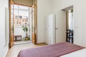 a bedroom with a bed and a large window at Apartment Bolhao Market by Sweet Porto in Porto