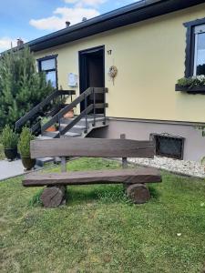 a wooden bench sitting in the grass in front of a house at Ferienhaus Schwalbennest in Gerolstein