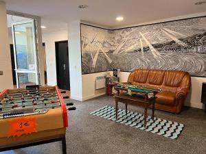 uma sala de estar com um sofá e uma mesa de matraquilhos em Auberge de Jeunesse HI Nice Les Camélias em Nice