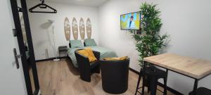 a living room with a bed and a table and a table at **Studio Holidays** Centre ville 20 m2 in Chalons en Champagne