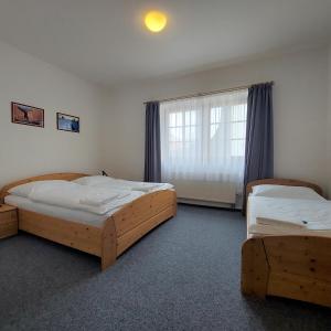 a bedroom with two beds and a window at Hotel Vltava in Frymburk