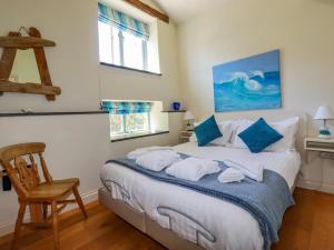 a bedroom with a bed with towels on it at Periwinkle in Bude