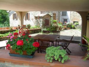 un patio con una mesa y algunas flores. en Case La Sassa, en Marliana
