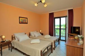 een hotelkamer met twee bedden en een televisie bij Rooms Aurora in Pula