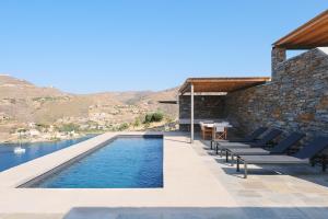 a villa with a swimming pool and a house at Kymo Kea in Otzias