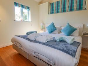 a bedroom with a bed with blue pillows on it at Cameo in Bude