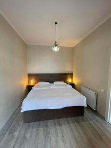 1 dormitorio con 1 cama blanca grande en una habitación en G&M Apartament, en Tiflis