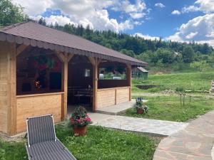 ein hölzerner Pavillon mit Tisch und Stühlen in der Unterkunft Casa Cris in Durau