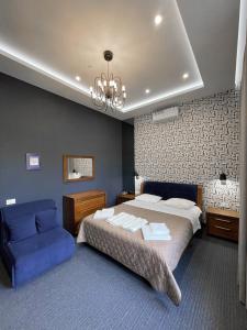 a bedroom with a large bed and a blue couch at Levanevsky Hotel in Odesa