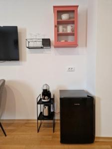 a room with a black refrigerator next to a tv at Jazz Rooms and Apartments in Rovinj