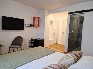 a bedroom with a bed and a television on the wall at Jazz Rooms and Apartments in Rovinj