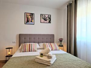 a bedroom with a bed with towels on it at Jazz Rooms and Apartments in Rovinj