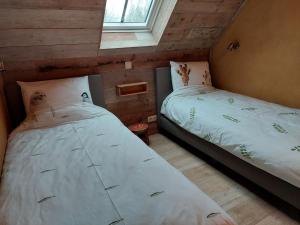 two twin beds in a room with a window at B&B Clogher Farm in Poperinge