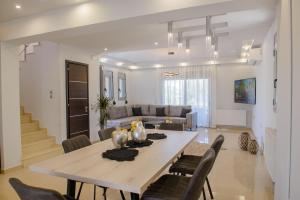 Atlas Villa في كريماستي: غرفة طعام وغرفة معيشة مع طاولة وكراسي