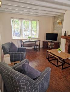 een woonkamer met 2 banken en een tv bij Stunning 2 bed Cottage in Saddleworth in Dobcross