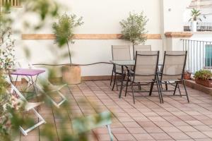 a patio with chairs and a table on a balcony at Green-Apartments Alto de Santa Cruz in Seville