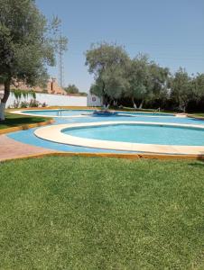 an empty swimming pool with trees and grass at Sevilla BRISAS VIP Valencina de la concepción in Seville