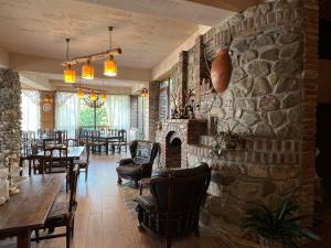 un restaurante con pared de piedra, mesa y sillas en Hillside Resort Telavi, en Telavi