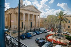 eine Gruppe von Autos, die vor einem Gebäude geparkt sind in der Unterkunft Independence Lovely Apartments in Valletta + 96 Fotos