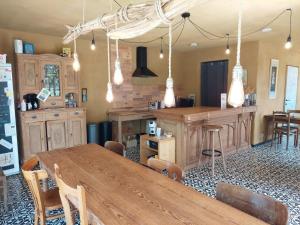 a kitchen with a wooden table and a bar at B&B Clogher Farm in Poperinge