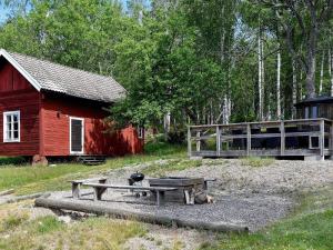 a picnic table in front of a red barn at 16 person holiday home in P LSBODA in Hjortkvarn