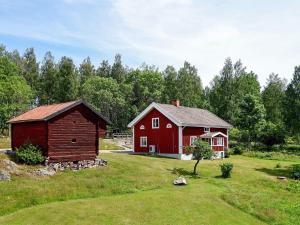 Czerwona stodoła i czerwony dom na polu w obiekcie 16 person holiday home in P LSBODA w mieście Hjortkvarn