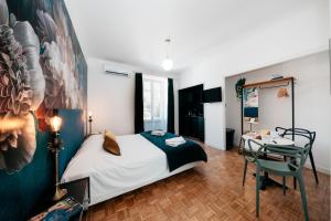 Les Précieuses Suites & Spa II في أفينيون: غرفة نوم بسرير ومكتب وطاولة