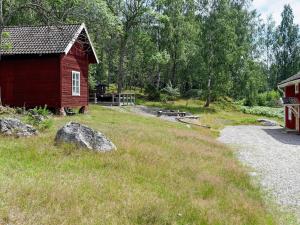 a red barn in a field next to a building at 16 person holiday home in P LSBODA in Hjortkvarn