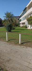 a fence in front of a field with a building at Ona Apart por Día - Departamentos con cochera in Corrientes