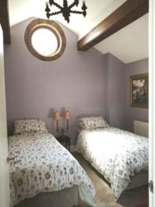 1 dormitorio con 2 camas y espejo en la pared en The Jewel in the Crown, countryside escape, en Rushton Spencer