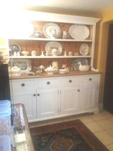 a white cabinet with plates and dishes on it at The Jewel in the Crown, countryside escape in Rushton Spencer
