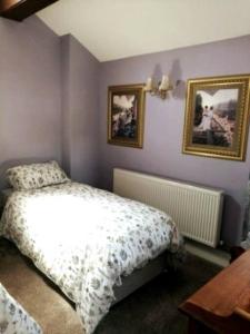 a bedroom with a bed and two pictures on the wall at The Jewel in the Crown, countryside escape in Rushton Spencer